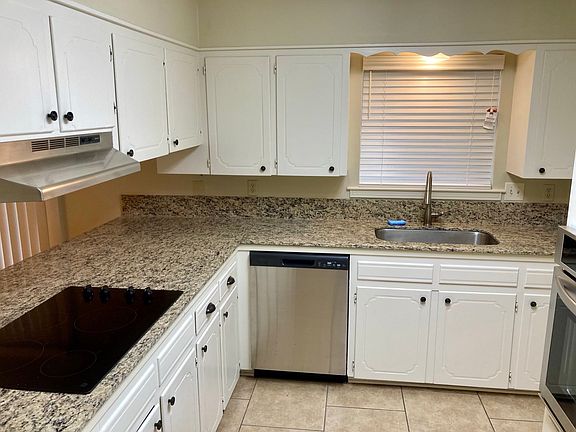 Kitchen with granite tops and smooth cooktop.