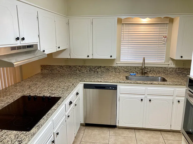 Kitchen with granite tops and smooth cooktop.