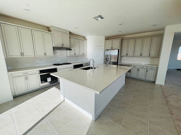 Main Kitchen with granite island, full cabinetry & pantry and GE Appliances (2 ovens, one microwave, one dishwasher, one range/hood, one double door refrigerator)