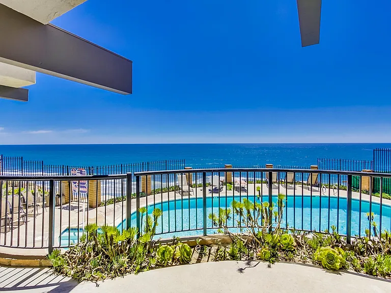 Community pool and jacuzzi overlooking the ocean.