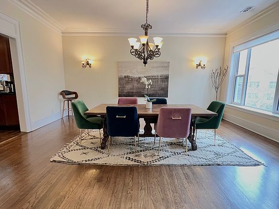 Formal Dining - hardwood floors throughout, picture window, chandelier and wall sconce lighting. Opens to kitchen and living with French doors.
