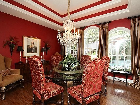  Elegant dining room is the ideal setting for formal occasions with its dazzling chandelier, double recessed ceiling, and a wall of arched windows overlooking the pool and spa