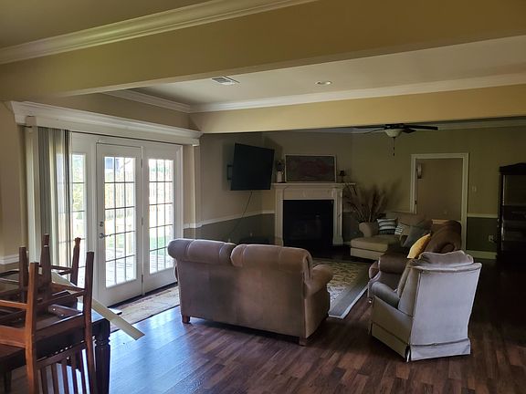 Dining and living room w fireplace, trim accents, wall mounted swivel 48in TV and patio doors to outside deck.