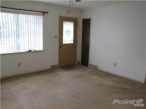 Living room has a large set of windows to brighten the room.