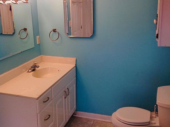 Bathroom with large vanity, medicine cabinet and storage above commode.
