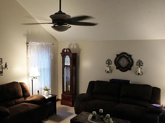 Additional view of great room with vaulted ceiling and ceiling fan with light