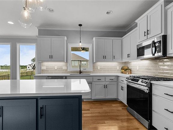 Beautiful pendant lighting above the kitchen sink and kitchen island.