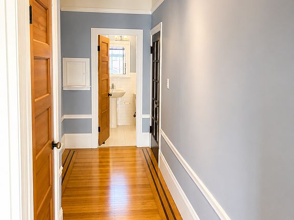 Hallway from living room to front door / bathroom; track lights; hardwood floor