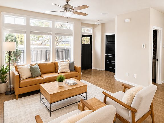 Living room with large windows, natural light, and front entry access