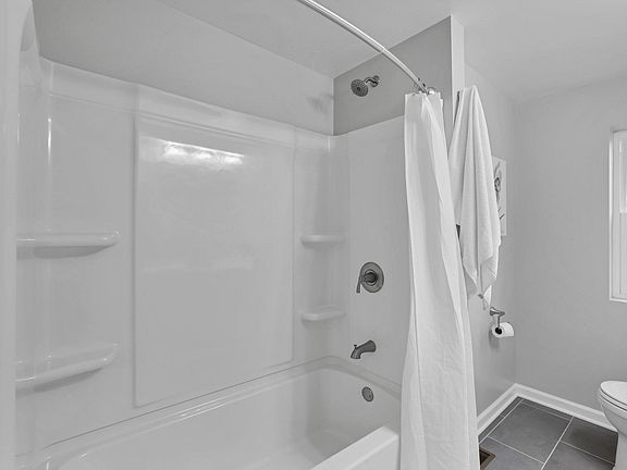 Luxury bathroom with tub shower combo, bathroom exhaust fan and swivel towel racks