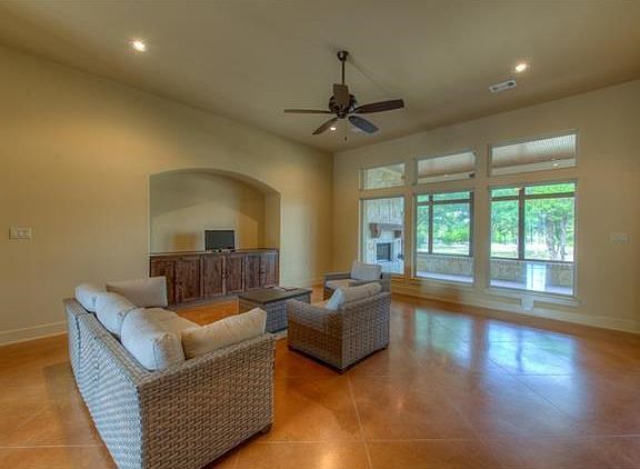 The family room featuring tall ceilings, stained concrete floors and a wall of windows looking onto the back screened in patio / 2nd outdoor living space.