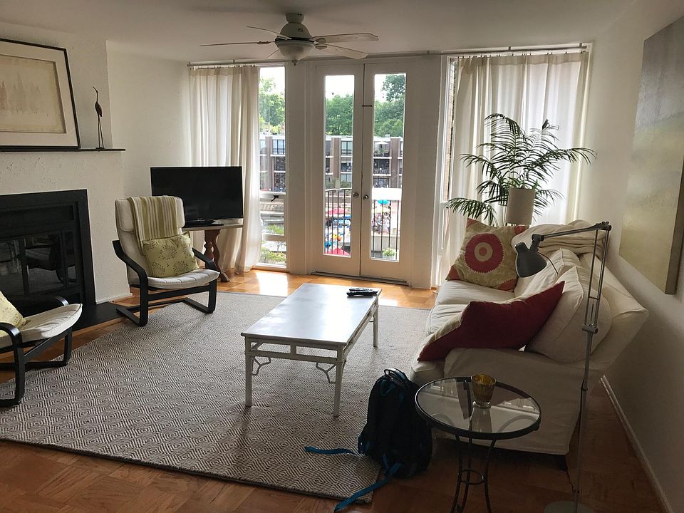 Living area with fireplace and balcony doors overlooking the Lake Anne and the plaza. Hair salon, Art Gallery and brew pub are in the plaza area
