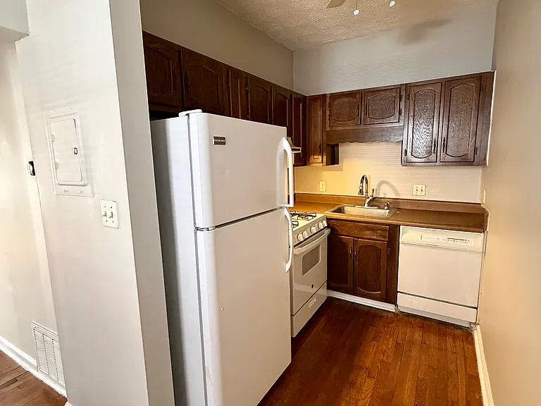 Kitchen with refrigerator with ice maker, gas stove, stainless steel sink, disposal and dishwasher.