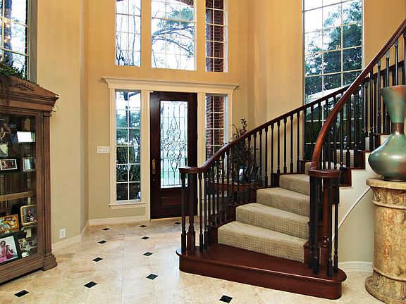 Winding staircase and stone flooring in this inviting foyer.