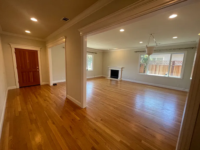 Foyer and Living Room- Grand, light-filled living room featuring an elegant gas fireplace and bespoke blackout drapery for an immersive home-theater experience.