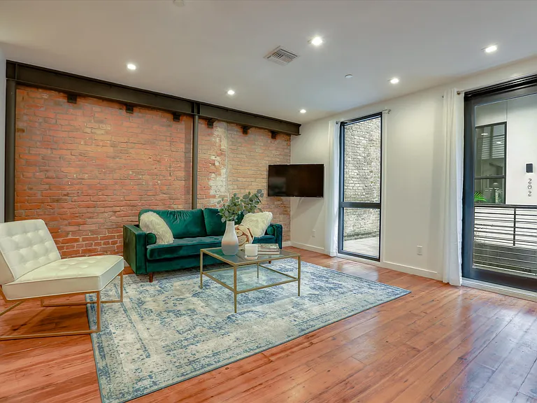 The living area has exposed brick and reclaimed pine hardwood floors from a historic building in the French Quarter.