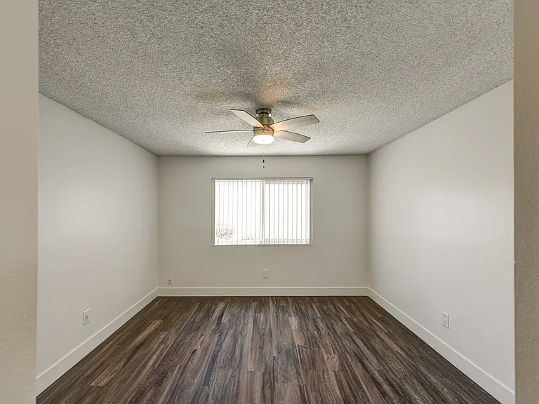 an bedroom with a ceiling fan and a window