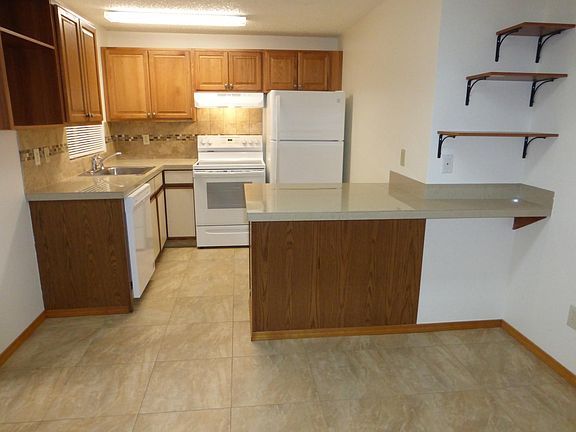Clean and well lit kitchen with window in front of sink.
