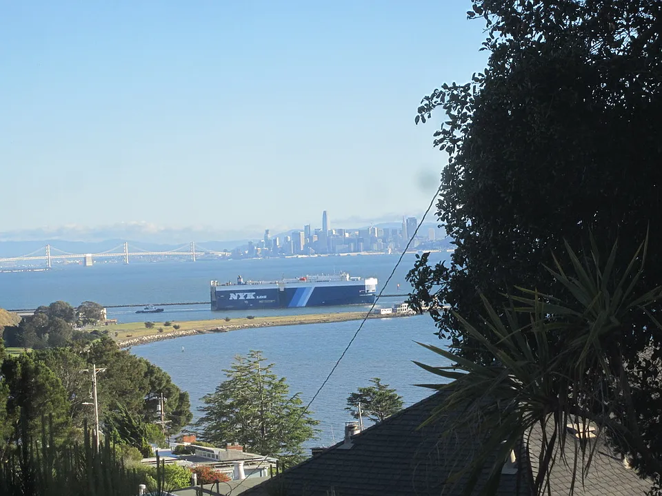 View from living room solar atrium of bay, large ship, bay bridge and San Francisco.