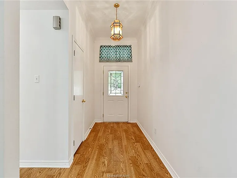 front entry with wood floors and coat closet