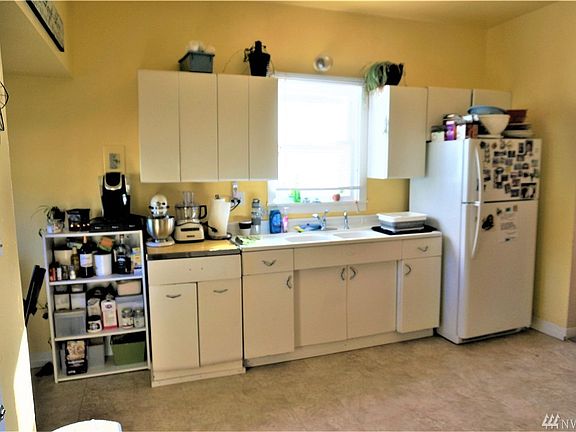 Cool old fashion kitchen with original sink and turn of the century cabinets. 