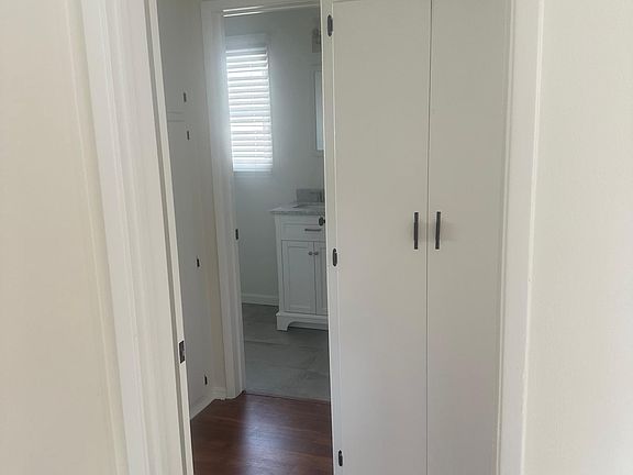 Hallway to bathroom (new) and bedroom with closets in the hallway.