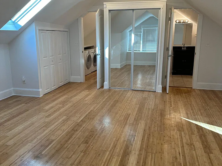 Bedroom view showing open laundry room door and bathroom door