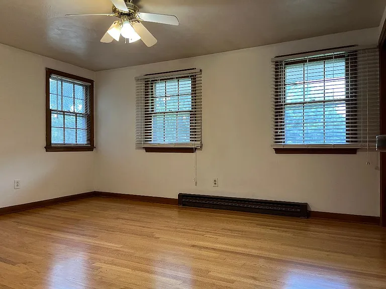 Master bedroom with hardwood floors and ceiling fan