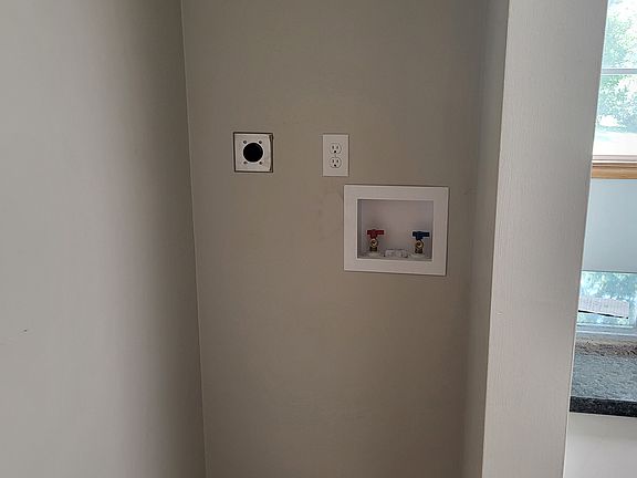 stackable washer and dryer hook up located in kitchen across from pantry