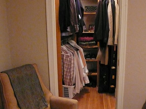 Walk-in closet with light wood shelving units