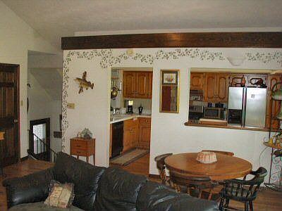 Large kitchen with breakfast bar and big garden window for plants. Looks throu