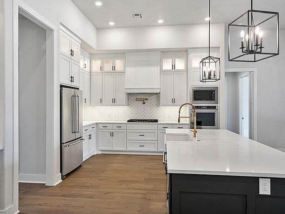 The upgraded kitchen has a large island with quartz countertops.