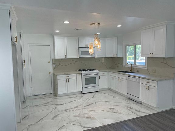New Kitchen, Quartz countertop and backsplash, white cabinets with gold trim. Door access to studio apartment