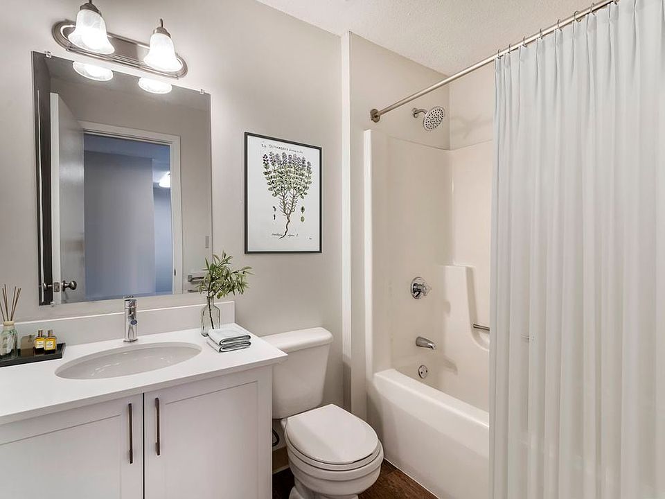Renovated Package I bath with white laminate countertops, white cabinetry, and hard surface flooring