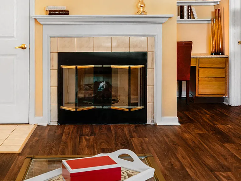 Elegant fireplace, crown molding, and wood-style floors