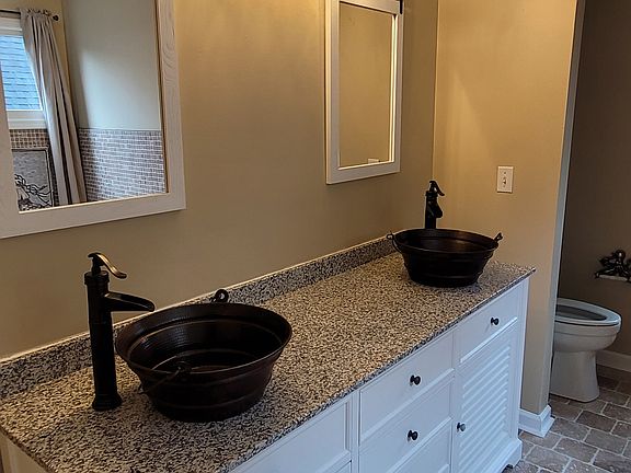 Master bath has been completely redone. Grantite countertops on a 72 inch James Martin Vanity with double vessel sinks. Farm style mirrors. Travertine stone on the floors.