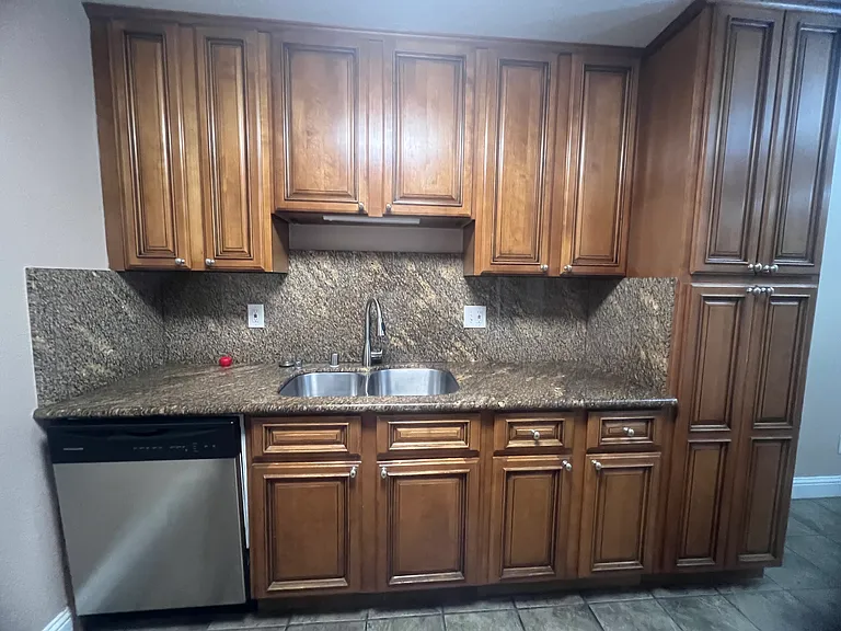 Kitchen with granite countertops, double sink, garbage disposal and dishwasher.