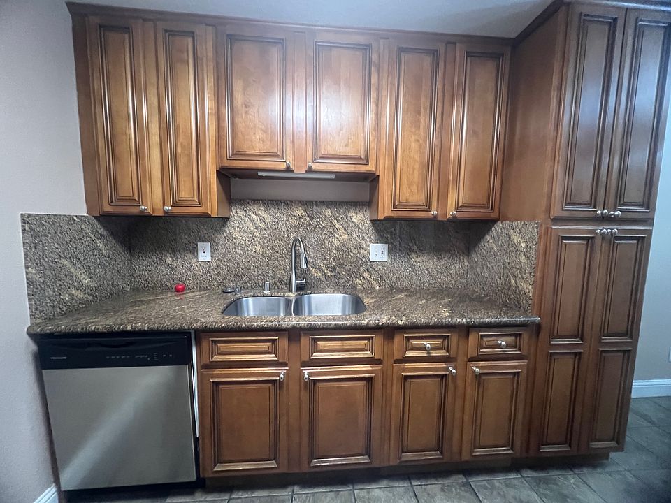 Kitchen with granite countertops, double sink, garbage disposal and dishwasher.