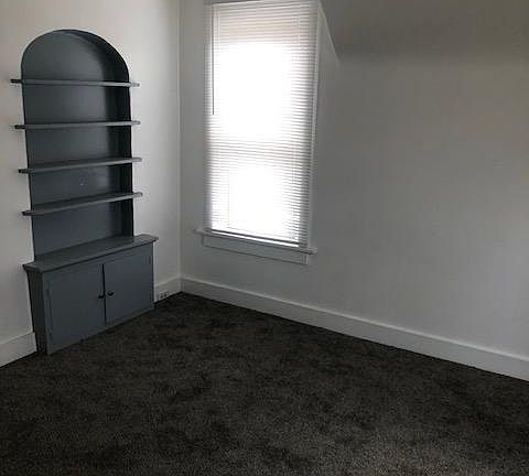 Large living room with built in bookshelf and storage
