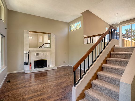 Living Room as seen from the Front Door!  Note how Open and Light and Bright the Home is! Flooring is a hardwood look laminate.  New carpet on Stairs and throughout home! Fireplace & Chimney have just been cleaned and inspected!