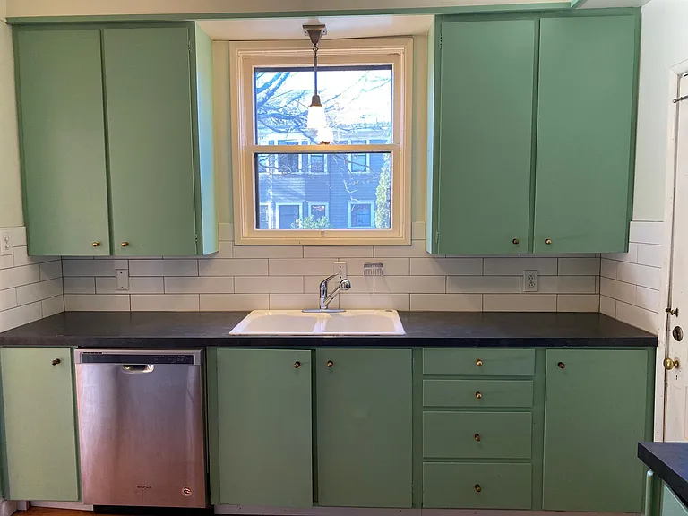 Kitchen with dishwasher, newly tiled and painted. Door leads to back porch