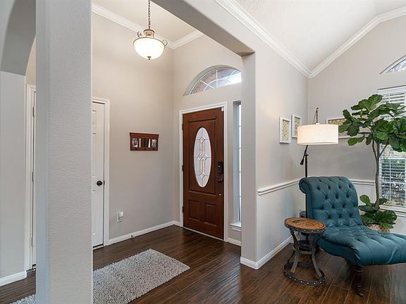 Welcoming entry with tall ceilings and crown molding accentuated with a charming pendant light!