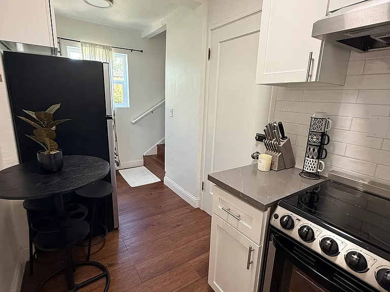 Small kitchen with a refrigerator and stove including oven.