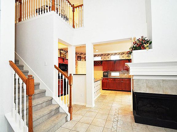 Oversized gas log fireplace wraps around the corner from the family room