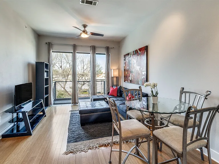 Open living area with large, bright windows and balcony.