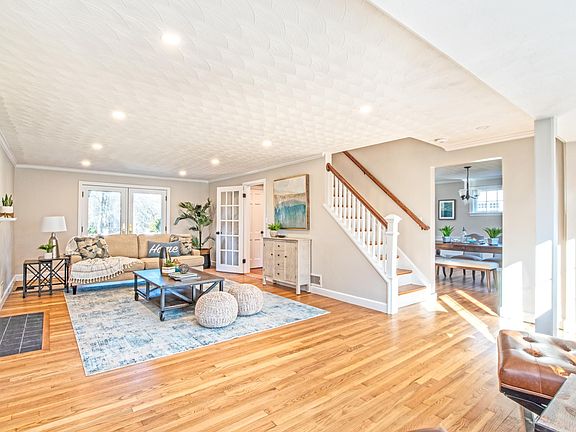 Living room with recessed lighting and hard wood floors. Atrium doors behind couch lead to deck.