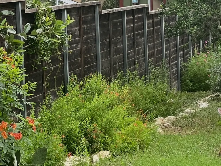 Side yard fenced area next to side road.