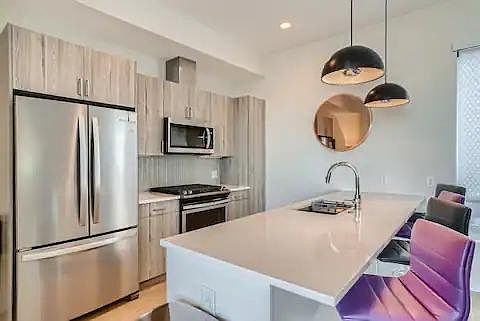 Kitchen with stainless steel fridge, dishwasher, and microwave