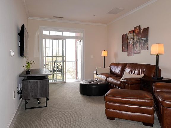 Living area with natural sunlight leading to private balcony