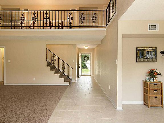 View of family room, dining area, front door and upstairs landing.